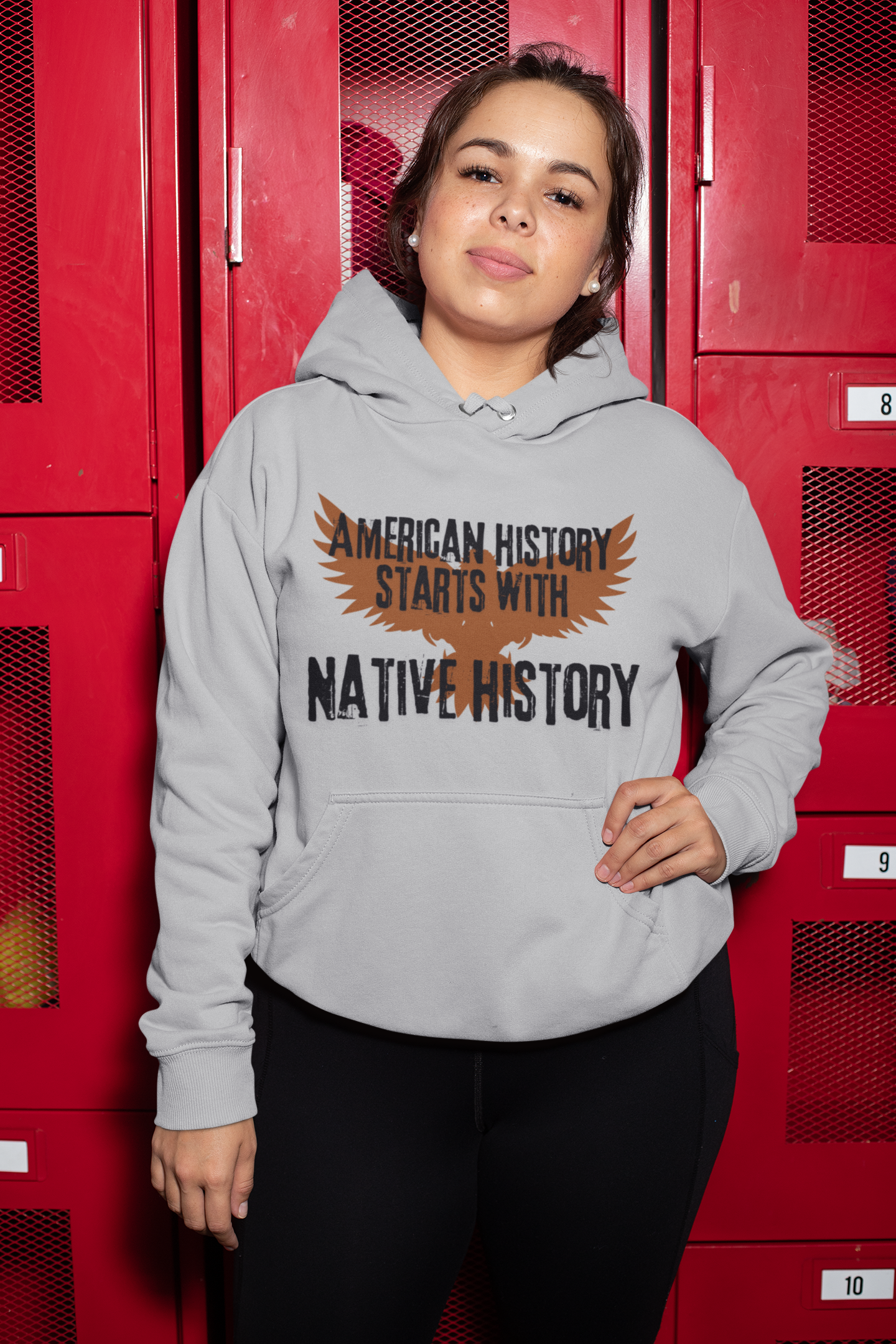 Brown outline of an eagle in the background, American History Starts With Native History printed in black bold cracked font  - sport grey 