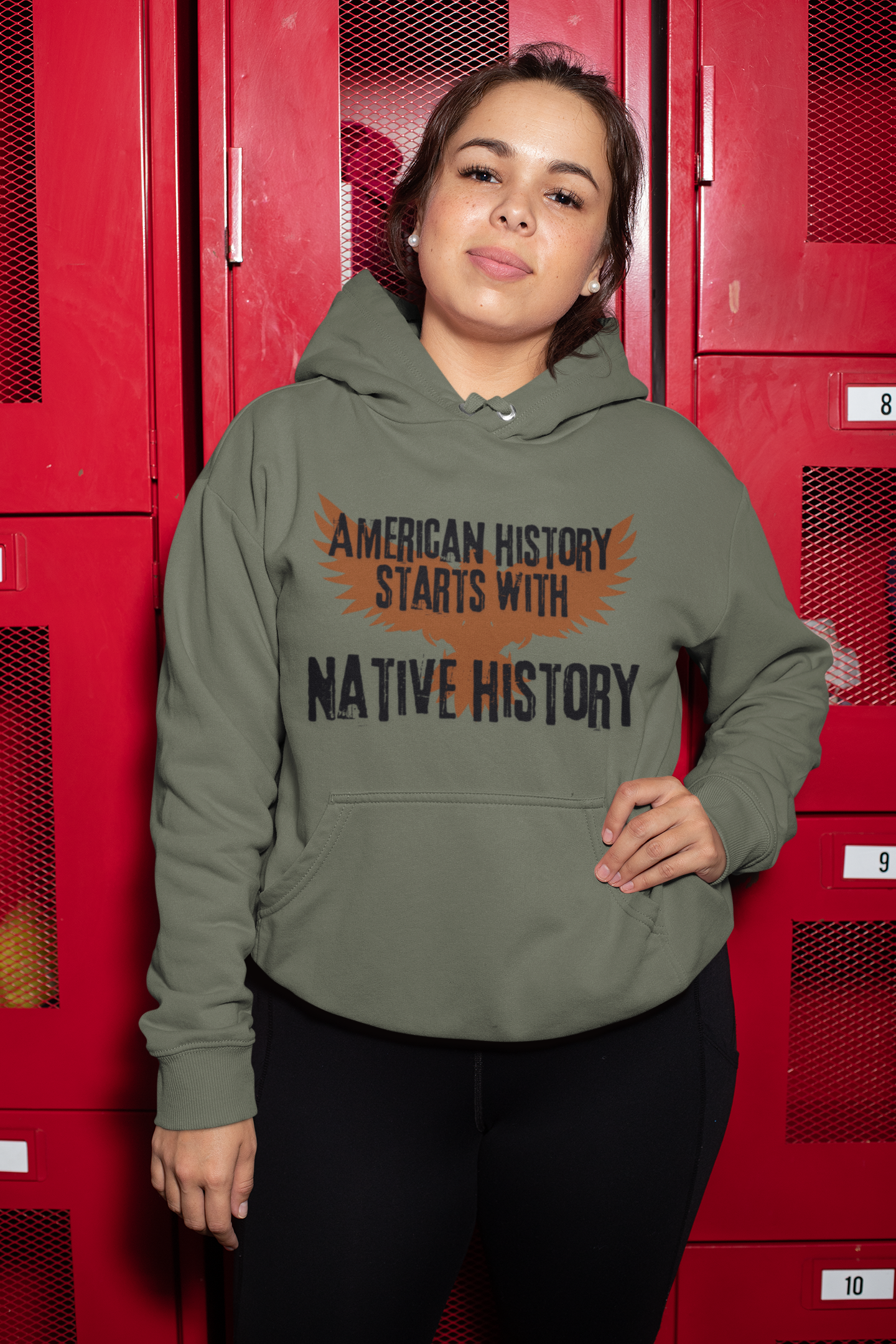 Brown outline of an eagle with its wings open in the background, American History Starts With Native History printed in black bold cracked font  - Military Green 