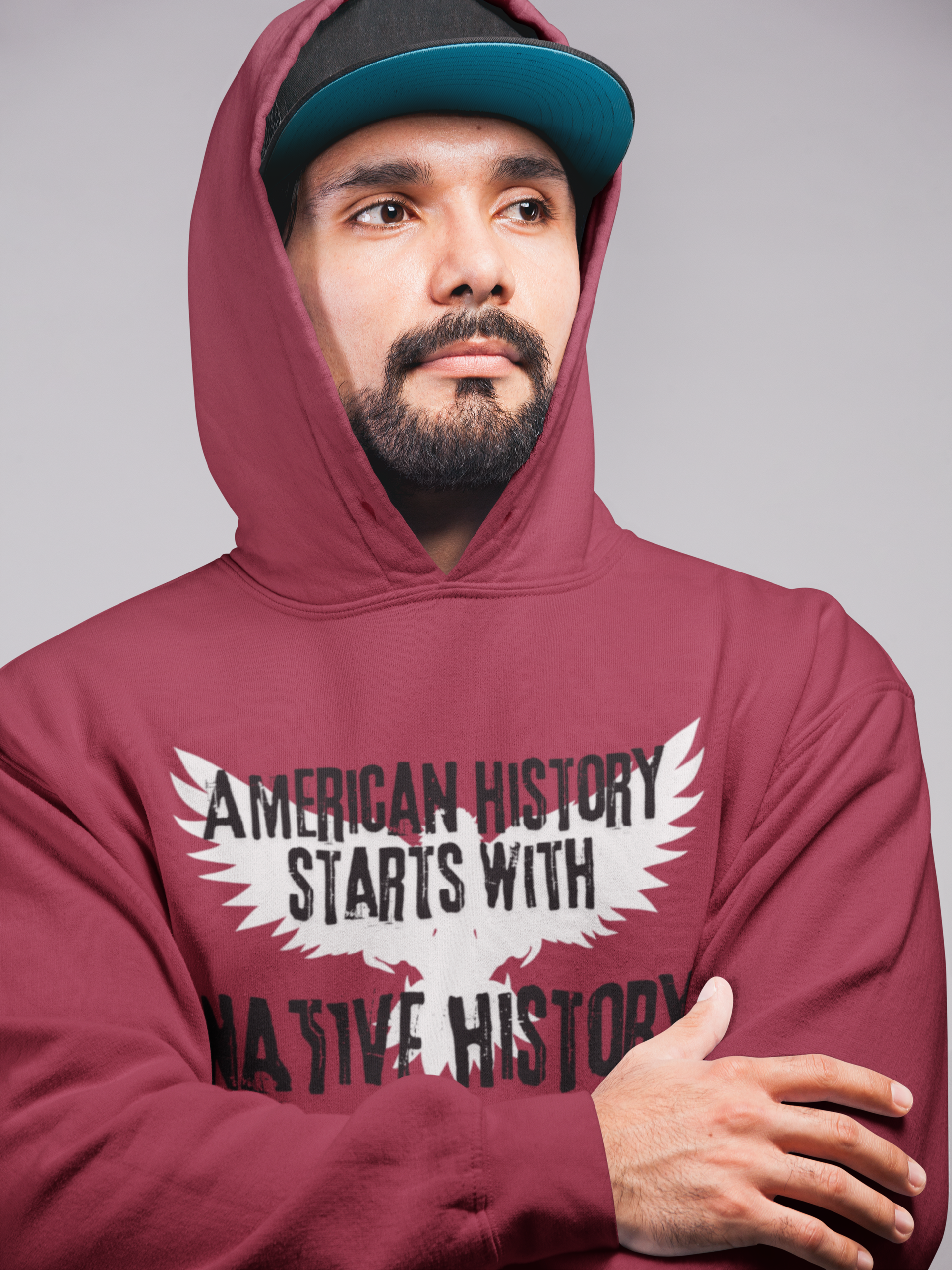 White outline of an eagle with its wings open in the background, American History Starts With Native History printed in black bold cracked font  - Cardinal Red Hoodie