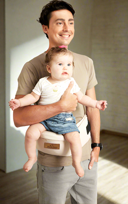 Dad carrying a baby with the baby hip carrier in creamy white. Clip this belt on and continue your day. Relieve back pain from holding your baby. For mom's, Dad's,  siblings, and anybody who wants hold an adorable baby. 