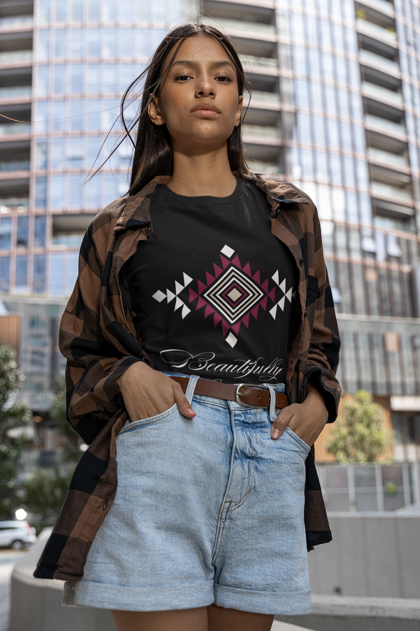 black t-shirt with a gorgeous tribal pattern in burgundy, beige, and white. Beautifully Indigenous printed in cursive white font underneath