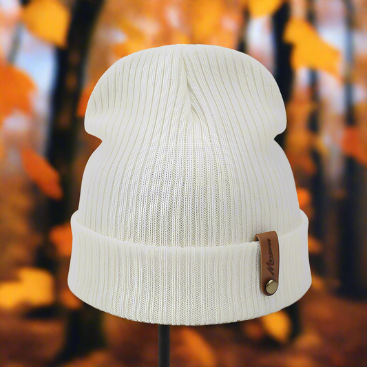 Indulge in the comfort of this Classic Cozy Beanie. A standard shape with a slightly high top in a knit style with a small brown leather buttoned detail tag where the beanie folds over - White