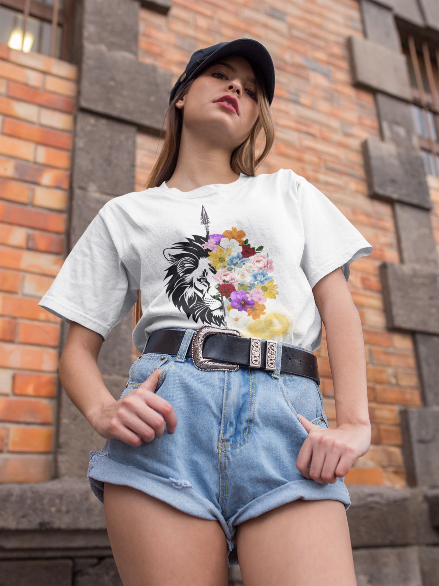 Leo Horoscope Tshirt. Half of a lions face cut down the middle by an arrow. The other half is a beautiful assortment of multicolored flowers with Leo printed in the corner in neon lit yellow font, printed on a white shirt.