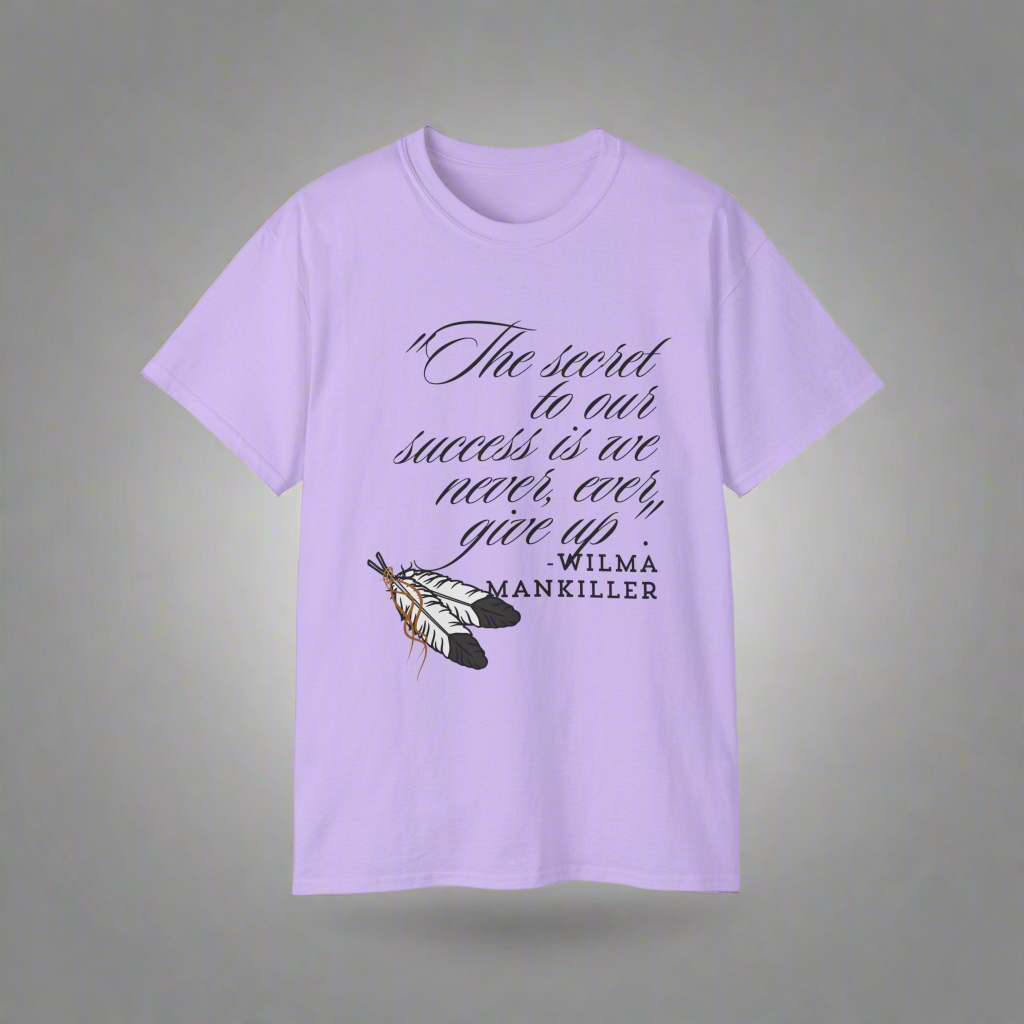 Native American Success Tshirt - Orchid Purple shirt quoting Wilma Mankiller stating the secret to our success is that we never ever give up. Eagle feathers in the corner tied together with leather string. 