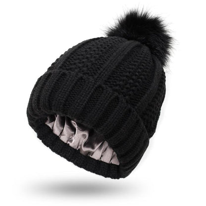 Pom Pom Beanie in black with a knitted design and fur pom pom. This beanie is Satin Lined so say goodbye to frizzy beanie hair.