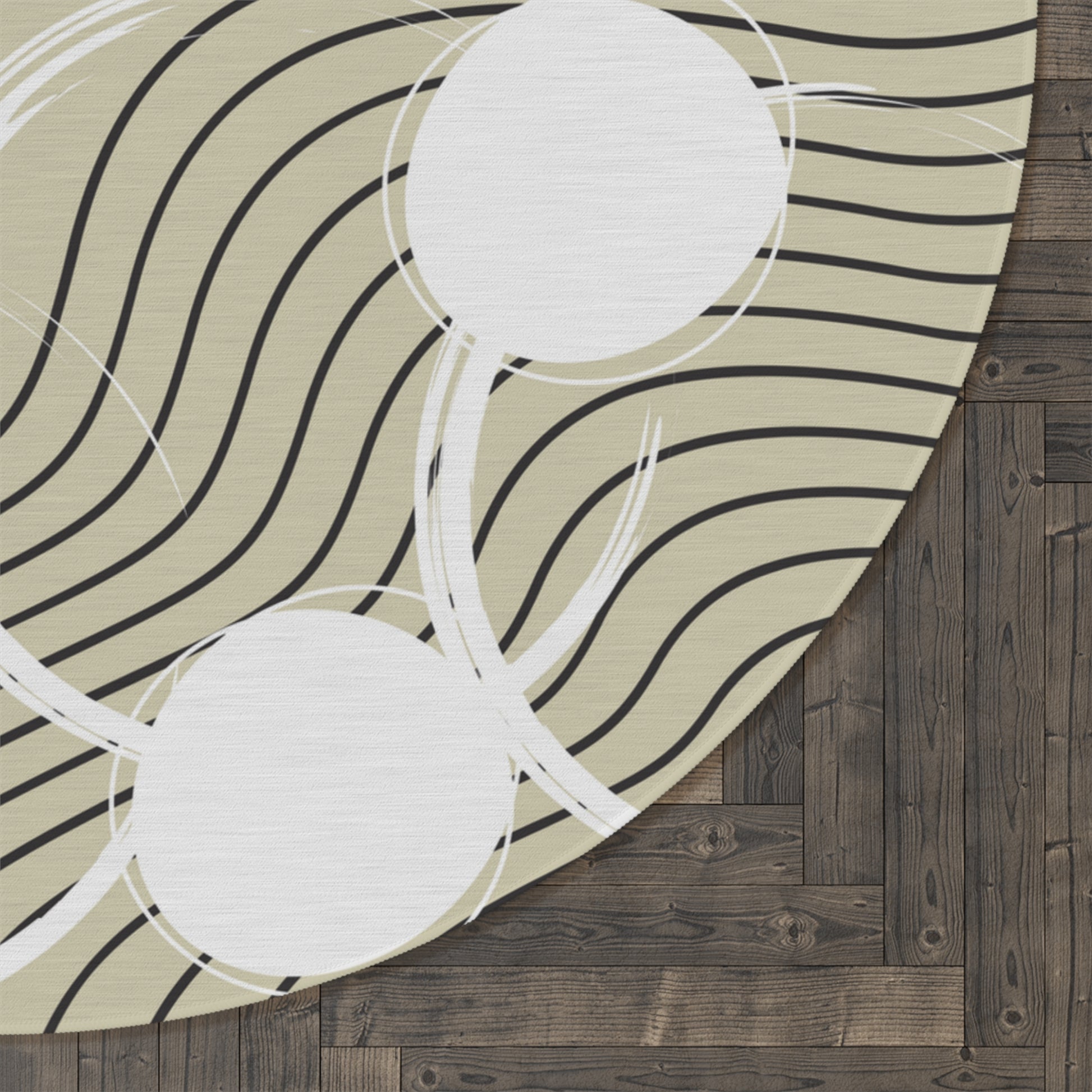 neutral colored round area rug with a cream tan colored base with white circles and black abstract lines