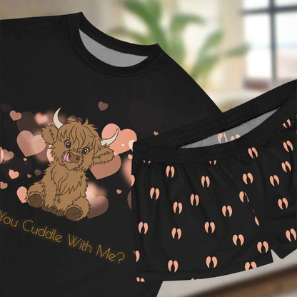 Scottish Highland Cow Pajamas. Black AOP, Scottish Highland Cow on a background of pink hearts with "will you cuddle with me?" printed underneath in a glowing yellow font. Pink cow print print pattern all over the shorts - back blank