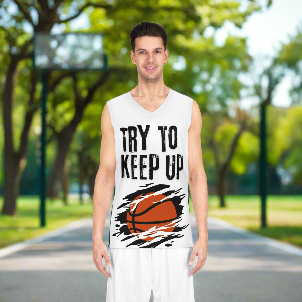 White basketball jersey with an orange basketball across the belly with a black background. Slash marks across the image. Try to keep up in large cracked font across the chest